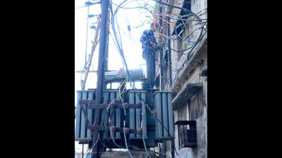 A PSPCL employee repairs a transformer in Ludhiana on Saturday. (HT Photo) A PSPCL employee repairs a transformer in Ludhiana on Saturday. (HT Photo)