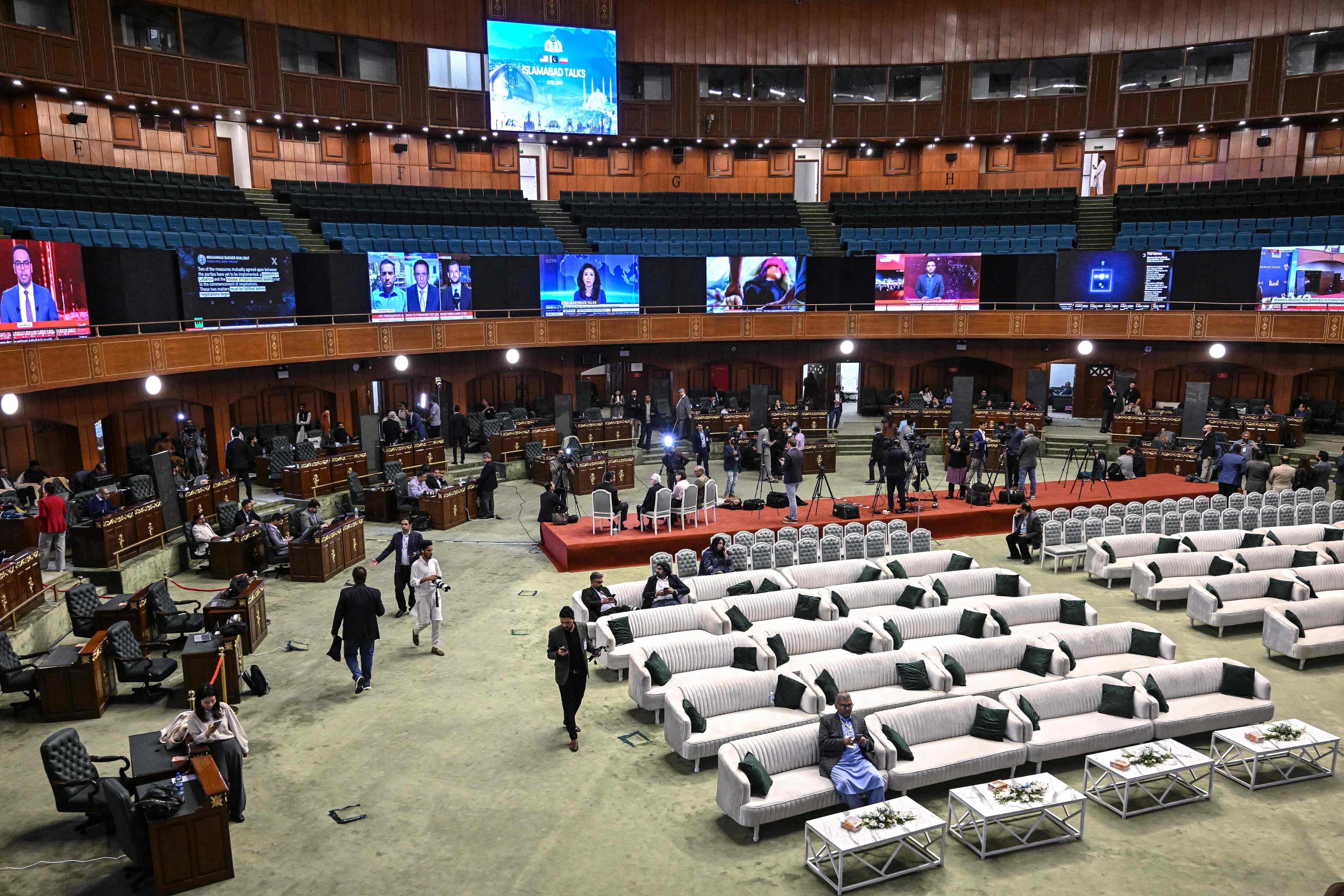 Journalists work at a media facilitation center ahead of US-Iran peace talks in Islamabad on April 11, 2026. (AFP)