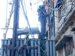 A PSPCL employee repairs a transformer in Ludhiana on Saturday. (HT Photo) A PSPCL employee repairs a transformer in Ludhiana on Saturday. (HT Photo)