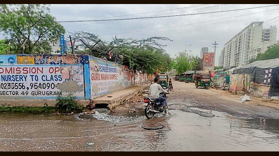 A stretch of Badshahpur–Kadarpur Road flooded with sewage overflow, as seen earlier this month. (HT Photo)