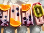 Bright, playful popsicle lined up with fruit on ice