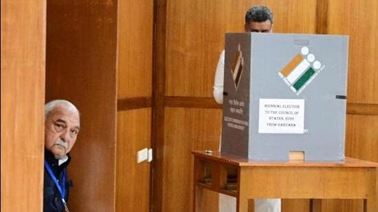 Haryana Congress Legislature Party (CLP) leader and former chief minister Bhupinder Singh Hooda looking on as Panchkula MLA and ex-deputy CM Chander Mohan casts his vote for the Rajya Sabha election in Chandigarh on March 16. (HT file photo)