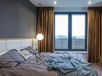 Sunlight blocked by blackout curtains creates a cool, dim room, offering comfort and relief from intense summer heat outside.
