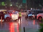 People move through sudden rain in the Mandi House area in New Delhi, India, on Friday, April 17, 2026.