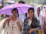 Girls share an umbrella to brave scorching heat on a hot day, in Prayagraj (Anil Kumar Maurya/HT)