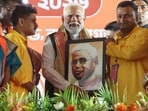 Prime Minister Narendra Modi receives a memento during the public rally ahead of the West Bengal Assembly elections 2026, in Medinipur on Sunday. 