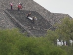 Forensic workers carry the body of a victim down a pyramid after authorities said a gunman opened fire, in Teotihuacan, Mexico.
