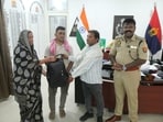 Ahirwar returning the bag of jewellery to its owners in the presence of SSP BBGTS Murthy in Jhansi on Tuesday (HT Photo)