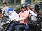 Commuters cover their faces to combat the scorching heat in Lucknow (HT Photo)