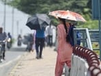 People shielding themselves with umbrella amid the hot weather conditions in Delhi (RAJ K RAJ /HT PHOTO)