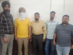SHO Gurjeet Singh (face covered) in the custody of vigilance bureau in Ludhiana on Tuesday. (HT Photo)