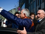 TOPSHOT - Security brings son of Iran's last shah, exiled Crown Prince Reza Pahlavi into a car after he was splashed with red liquid by an activist after a press conference at the BPK (Bundespressekonferenz) building in Berlin, on April 23, 2026.