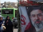 Iranian women walk past a banner depicting Iran's new supreme leader Ayatollah Mojtaba Khamenei .
