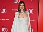 Dakota Johnson walked on the Time 100 Gala 2026 red carpet in a silver-grey gown from the Valentino Fall/Winter 2026 Ready-to-Wear collection. The ensemble is styled by Kate Young and features a strapless, floor-length column dress paired with a matching cape that cascades into a long train. The cape is secured at the neckline with an intricate, silver-embellished collar.&nbsp;