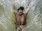 A boy dives into a canal to beat the heat on a hot summer day, in Kanpur. (PTI Photo)