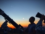 Couple stargazing together with a astronomical telescope. (astrosystem - stock.adobe.com)