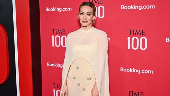 Hilary Duff walked down the red carpet in a cream-colored gown from the Anna October Spring 2026 collection. The floor-length, semi-sheer column dress was embellished with subtle, sparkling circular details and paired with a matching sheer cape that drapes over the shoulders. The actor completed her look with beautiful drop earrings and her hair tied in a bun.&nbsp;&nbsp;(Evan Agostini/Invision/AP)