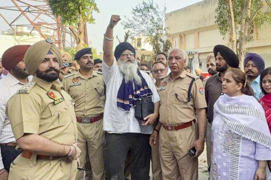 Gurjeet Singh Khalsa, centre, raising slogans as officials look on after he was brought down safely by the administration at Samana in Patiala district on Friday. (HT Photo) Gurjeet Singh Khalsa, centre, raising slogans as officials look on after he was brought down safely by the administration at Samana in Patiala district on Friday. (HT Photo)