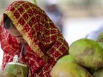A woman drinks coconut water to beat the heat in Prayagraj. (PTI PHOTO)