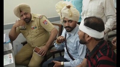 The groom, along with one of the injured, at the division number 2 police station in Ludhiana on Saturday. (HT Photo)