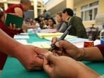 A Buddhist monk gets his finger inked before casting his ballot at a polling station in Dharamsala on Sunday. (AFP)