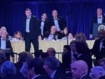 US Secret Service agents surround President Donald Trump before he was taken from the stage after a shooting incident outside the ballroom during the White House Correspondents Dinner, Saturday, April 25, 2026, in Washington.