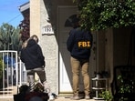 An FBI member stands outside a building next to the house associated with Cole Tomas Allen, the suspect in the shooting incident in Washington at the annual White House Correspondents' Association dinner, in Torrance, California, U.S.