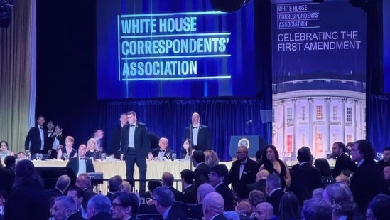 U.S. Secret Service agents surround President Donald Trump as he is taken from the stage after a shooting incident outside the ballroom during the White House Correspondents Dinner, Saturday, April 25, 2026, in Washington. (AP Photo/Alex Brandon)(AP)