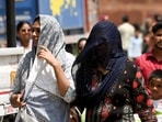 Women cover themselves with scarves on a hot summer day, near Red Fort, in New Delhi on Sunday.