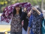 Locals seen protecting themselves from the heat on Monday. (RAJ K RAJ /HT PHOTO)