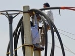 PSPCL lineman repairing the line connections in Ludhiana on Sunday. (Gurpreet Singh/HT)