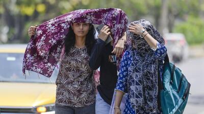 Locals seen protecting themselves from the heat on Monday. (RAJ K RAJ /HT PHOTO)