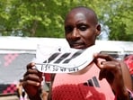 Kenya's Sabastian Sawe celebrates with an Adidas Adizero Adios Pro Evo 3 shoe.