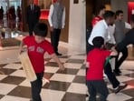 The video shows a child trying repeatedly to approach Virat Kohli for an autograph.