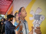 Residents from east Delhi's Sunder Nagri, mostly daily wage workers, making a mural about the impacts of extreme heat on workers.