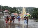 People walk with umbrellas during light rain on The Ridge, Shimla, on Tuesday. (Deepak Sansta/ HT)