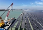 Workers install solar panels with a crane at the CNNC Tianwan tidal flat photovoltaic power plant in Lianyungang