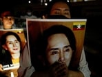 Migrants protesting against the military junta in Myanmar hold pictures of leader Aung San Suu Kyi, during a candlelight vigil at a Buddhist temple in Bangkok, Thailand, March 28, 2021.