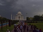 People gather at the Taj Mahal on a cloudy and rainy day during the summer season, in Agra, on Thursday. (PTI Photo)