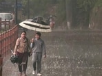 Commuters protect themselves amid heavy rainfall, in Shimla on Thursday. (ANI)