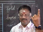 Former Tamil Nadu Chief Minister and DMK candidate for Bodinayakkanur constituency, O Panneerselvam, shows his ink-marked finger after casting his vote for the state Assembly elections, at a polling station, in Theni district.
