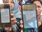 Women show their mobile phones after receiving an alert message as the Government of India formally launched its indigenous Cell Broadcast emergency alert system.