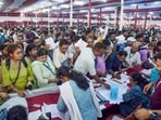 Election officials collect Electronic Voting Machines (EVMs) and Voter Verifiable Paper Audit Trail (VVPAT) machines from a distribution centre ahead of the final phase of voting, in Howrah on Tuesday.