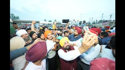 Punjab chief minister Bhagwant Mann takes pictures with Dasuya residents in Hoshiarpur on Sunday. (X)