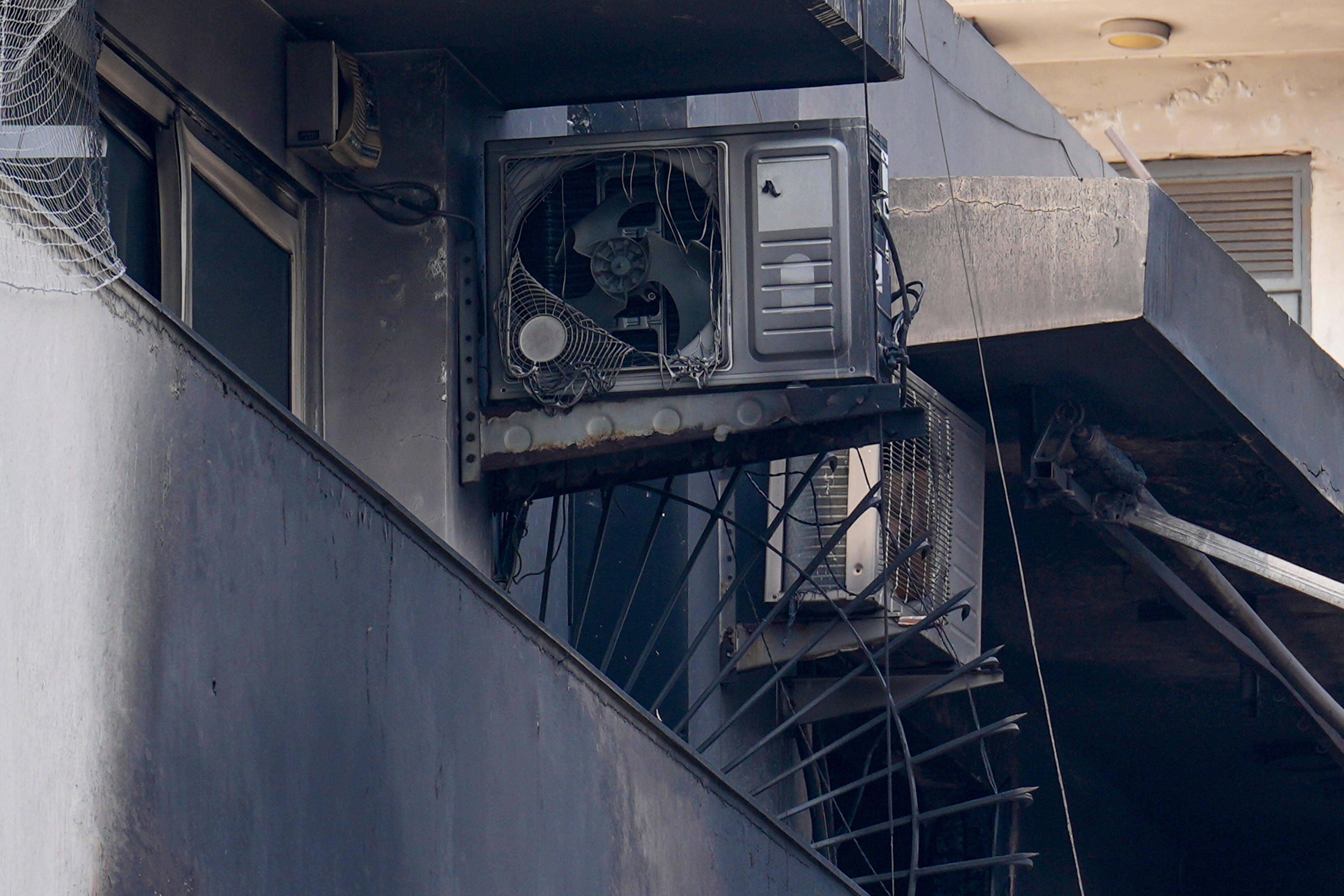 Charred remains of outdoor AC units and other items lie in the balcony of the four-storey residential building where a fire killed at least nine people. (PTI) Charred remains of outdoor AC units and other items lie in the balcony of the four-storey residential building where a fire killed at least nine people. (PTI)