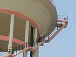 A woman who had climbed an overhead water tank in Prayagraj on Saturday. (HT Photo)
