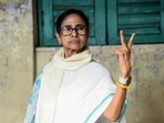 TMC candidate from Bhabanipur and West Bengal CM Mamata Banerjee, shows the victory sign as she arrives at the polling station to cast her vote, in Kolkata.