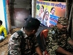 Two Central Reserve Police Force person sit near a election billboard of Trinamool Congress party chief Mamata Banerjee during the West Bengal Legislative Assembly election, in Kolkata, India, Monday, May 4, 2026. (AP Photo/Bikas Das)