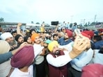Punjab chief minister Bhagwant Mann takes pictures with Dasuya residents in Hoshiarpur on Sunday. (X)