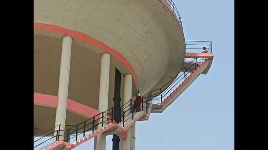 A woman who had climbed an overhead water tank in Prayagraj on Saturday. (HT Photo)